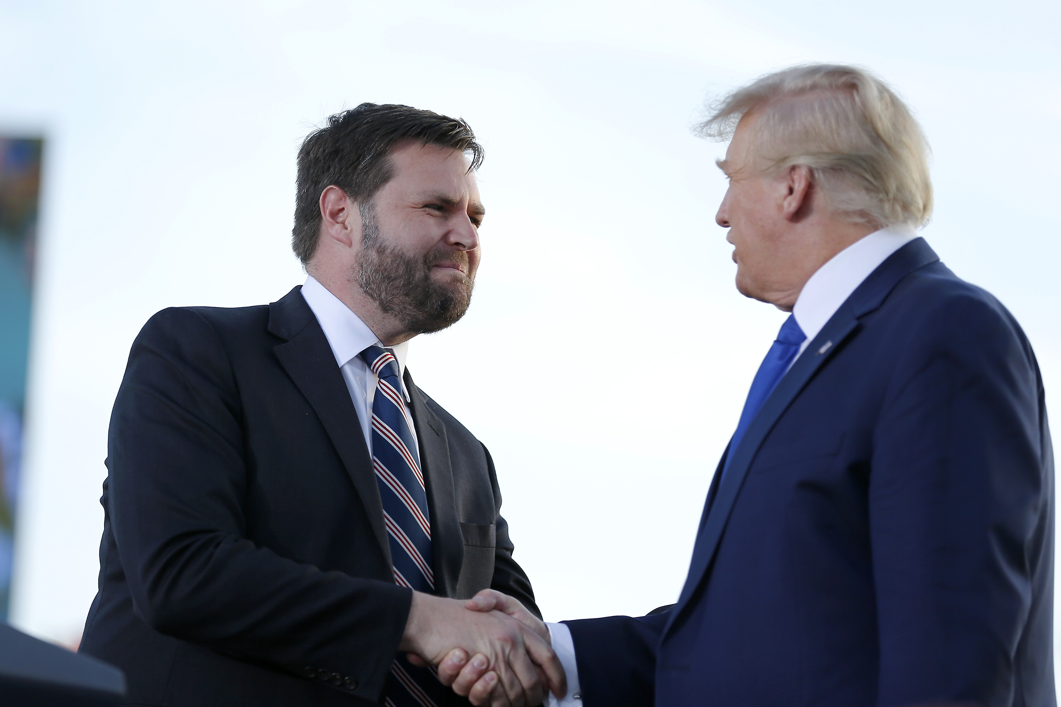 JD Vance, left, greets former President Donald Trump at a rally in 2022.