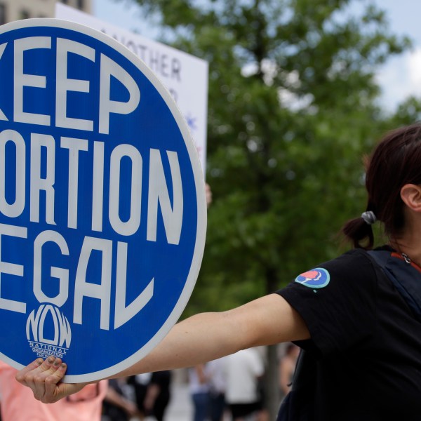 FILE - An. Abortion rights demonstrator holds a sign during a rally on May 14, 2022, in Chattanooga, Tenn. Women in Idaho, Tennessee and Oklahoma are challenging strict abortion laws that went into effect after the Supreme Court overturned Roe v. Wade last year. Two state lawsuits were filed on Tuesday, Sept. 12, 2023, in Idaho and Tennessee after women were denied care while facing harrowing pregnancy complications. Meanwhile, a federal complaint was filed in Oklahoma after a woman couldn't receive an abortion despite having a dangerous and nonviable pregnancy. (AP Photo/Ben Margot, File)