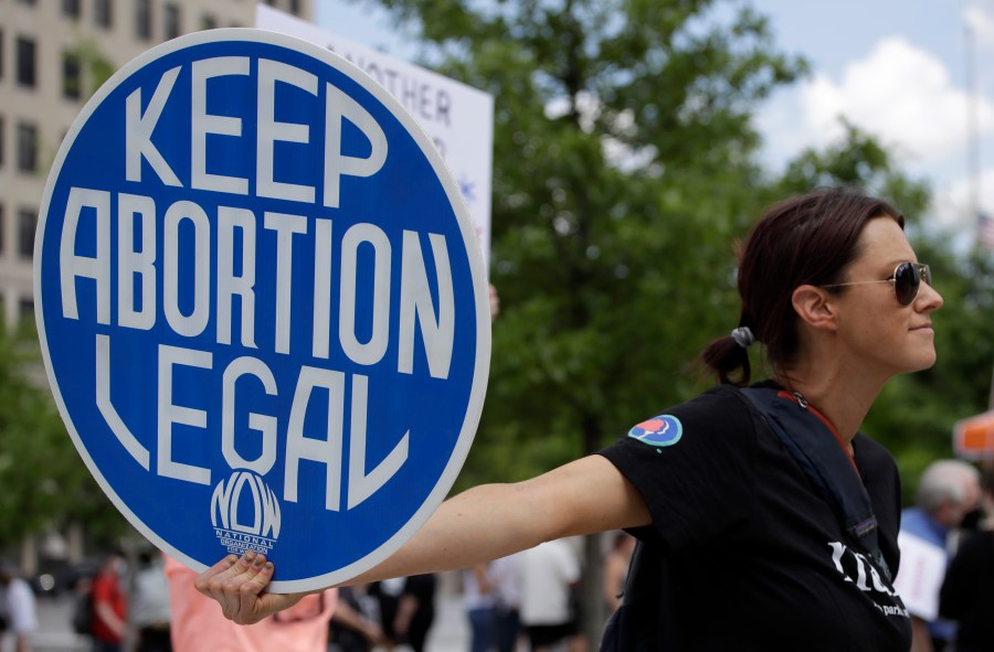FILE - An. Abortion rights demonstrator holds a sign during a rally on May 14, 2022, in Chattanooga, Tenn. Women in Idaho, Tennessee and Oklahoma are challenging strict abortion laws that went into effect after the Supreme Court overturned Roe v. Wade last year. Two state lawsuits were filed on Tuesday, Sept. 12, 2023, in Idaho and Tennessee after women were denied care while facing harrowing pregnancy complications. Meanwhile, a federal complaint was filed in Oklahoma after a woman couldn't receive an abortion despite having a dangerous and nonviable pregnancy. (AP Photo/Ben Margot, File)