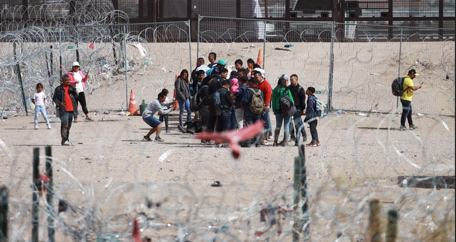 A Venezuelan migrant takes a photo of a group that managed to get past the Texas Army National Guard.