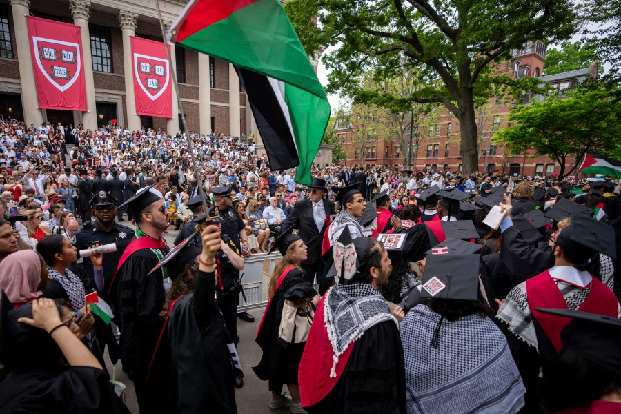 FILE - Graduating students hold Palestinian flags and chant as they walk out in protest over the 13 students who have been barred from graduating due to protest activities, during commencement in Harvard Yard, at Harvard University, in Cambridge, Mass., Thursday, May 23, 2024. (AP Photo/Ben Curtis, File)