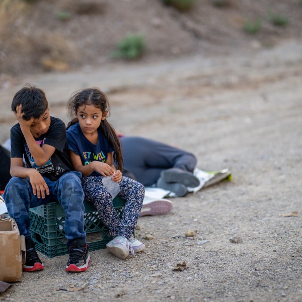 Children look towards the sky while waiting to be apprehended.