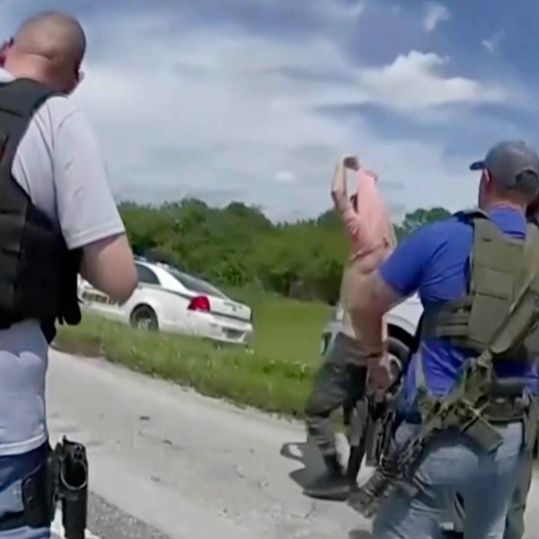 Law enforcement officers prepare to arrest Ryan Routh, the man suspected in the apparent assassination attempt of Donald Trump.
