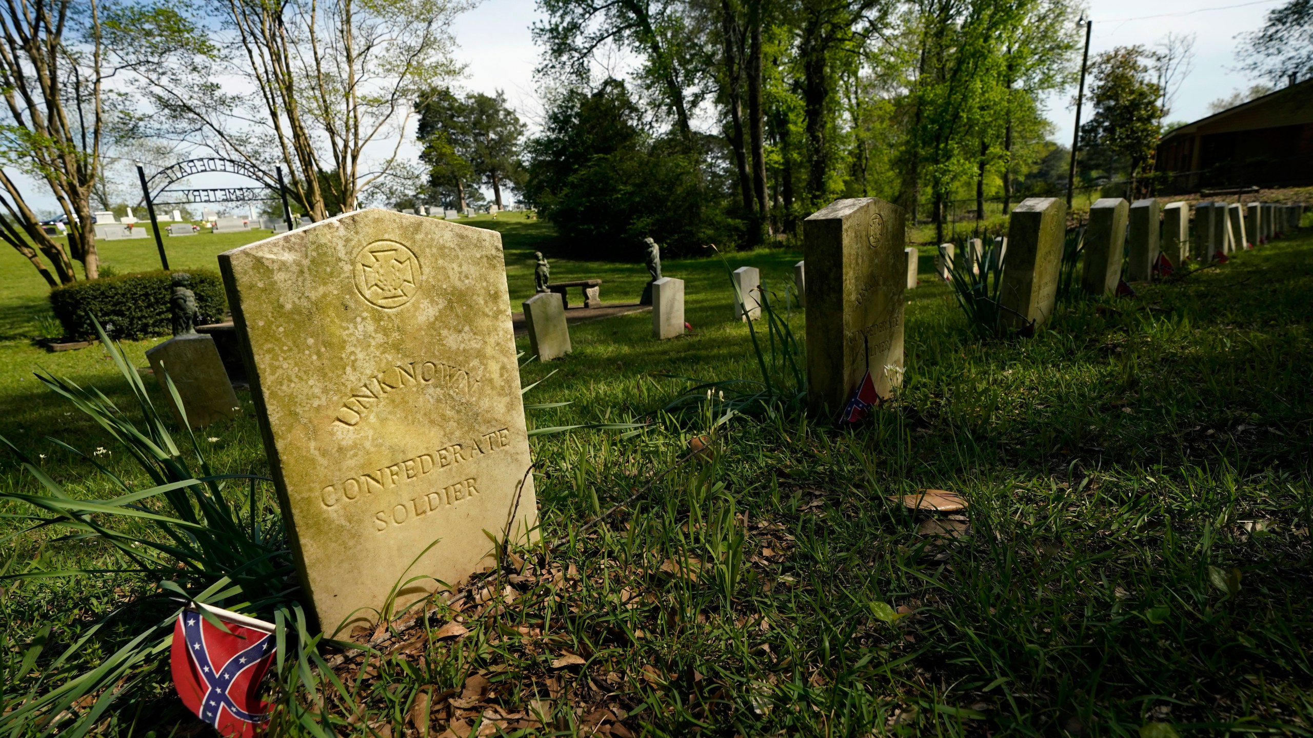 The sun sets on the grave markers in the Confederate cemetery in Grenada, Miss., April 12, 2023. (AP Photo/Rogelio V. Solis)