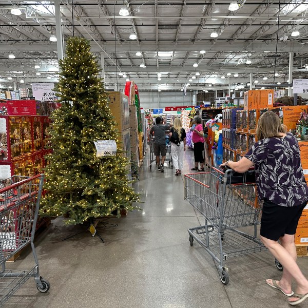 FILE - A shopper passes by a Christmas tree costing $600 on display in a Costco warehouse Sept. 12, 2024, in Thornton, Colo. (AP Photo/David Zalubowski, File)