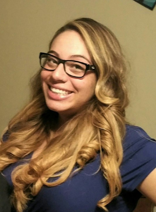 A woman with blond hair and black-rimmed glasses.