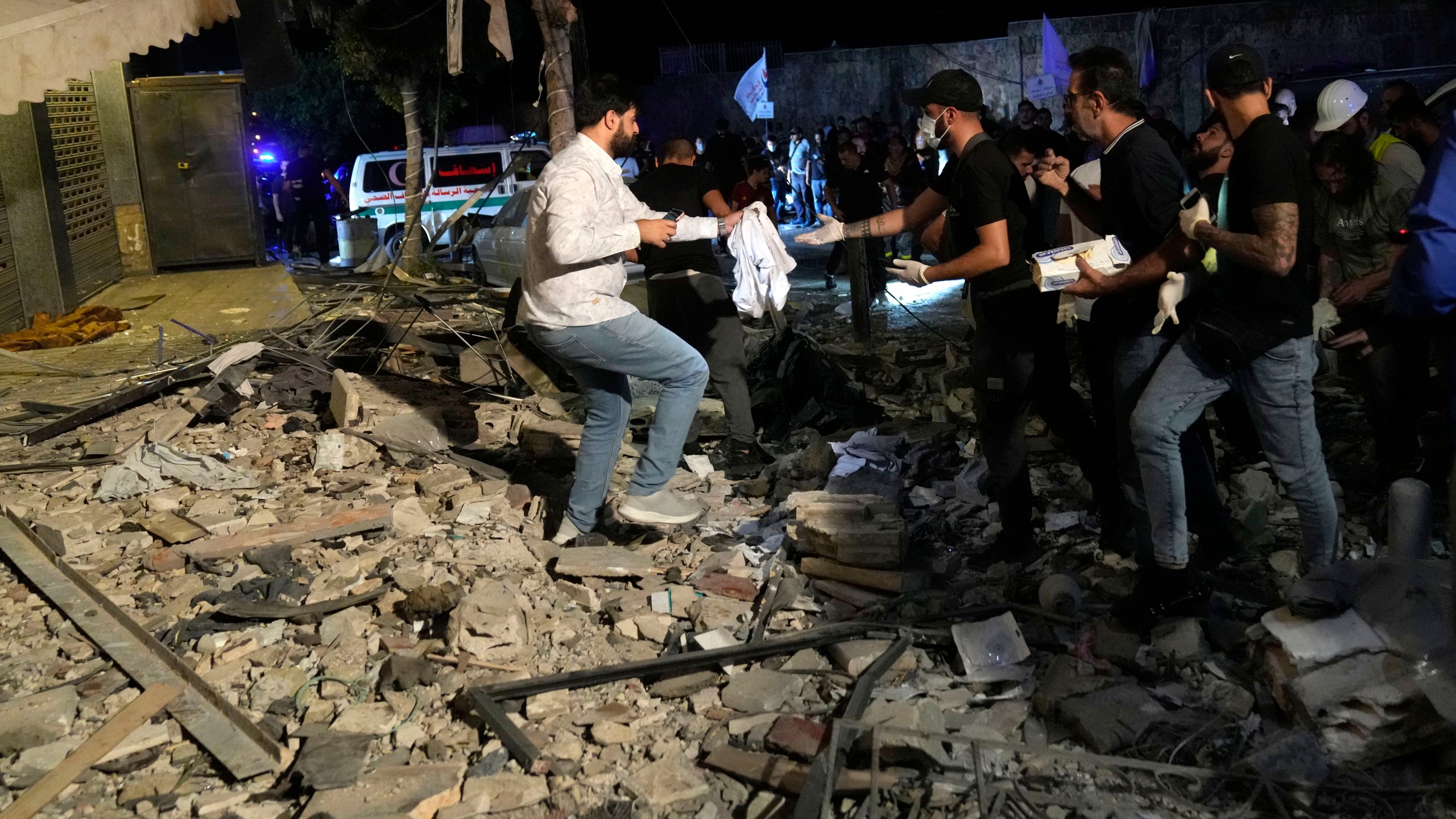People collecting remains of victims after an airstrike that hit an apartment in Beirut, Lebanon, Thursday, Oct. 3, 2024. (AP Photo/Hussein Malla)