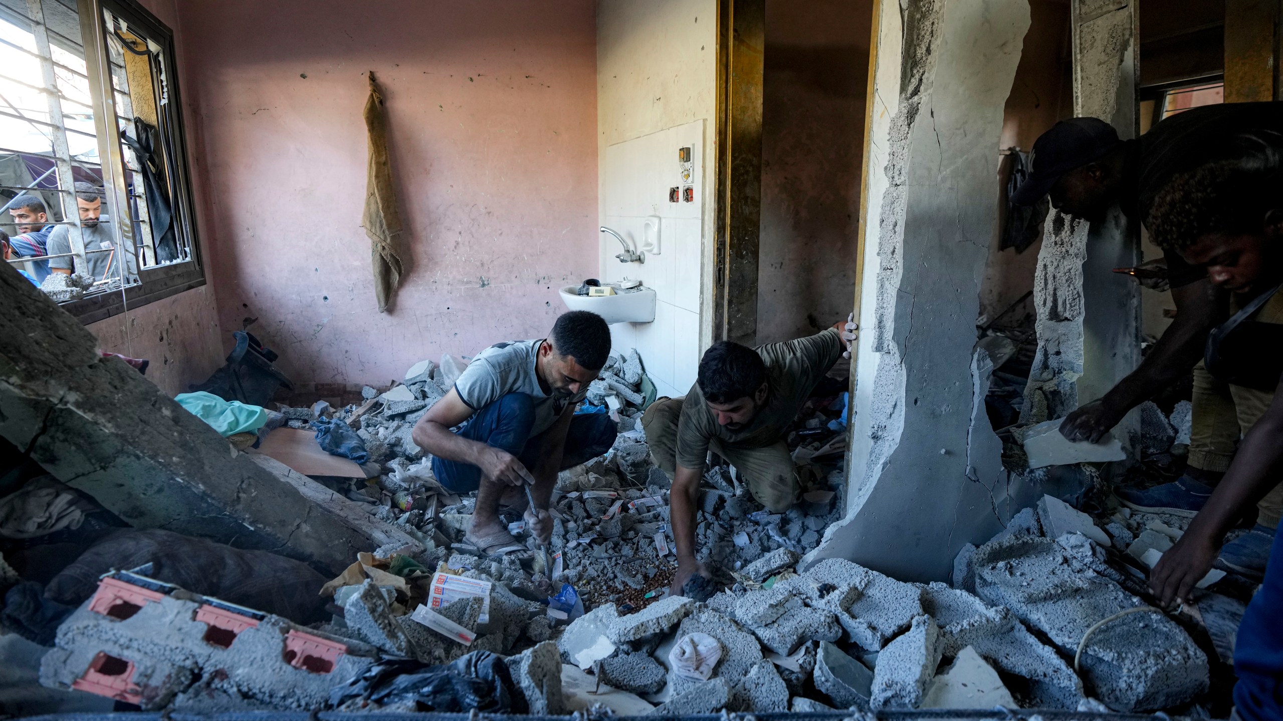 Palestinians search for the remains of their relatives killed in an Israeli bombardment of a school in Deir al-Balah, central Gaza Strip, Thursday, Oct. 10, 2024. (AP Photo/Abdel Kareem Hana)