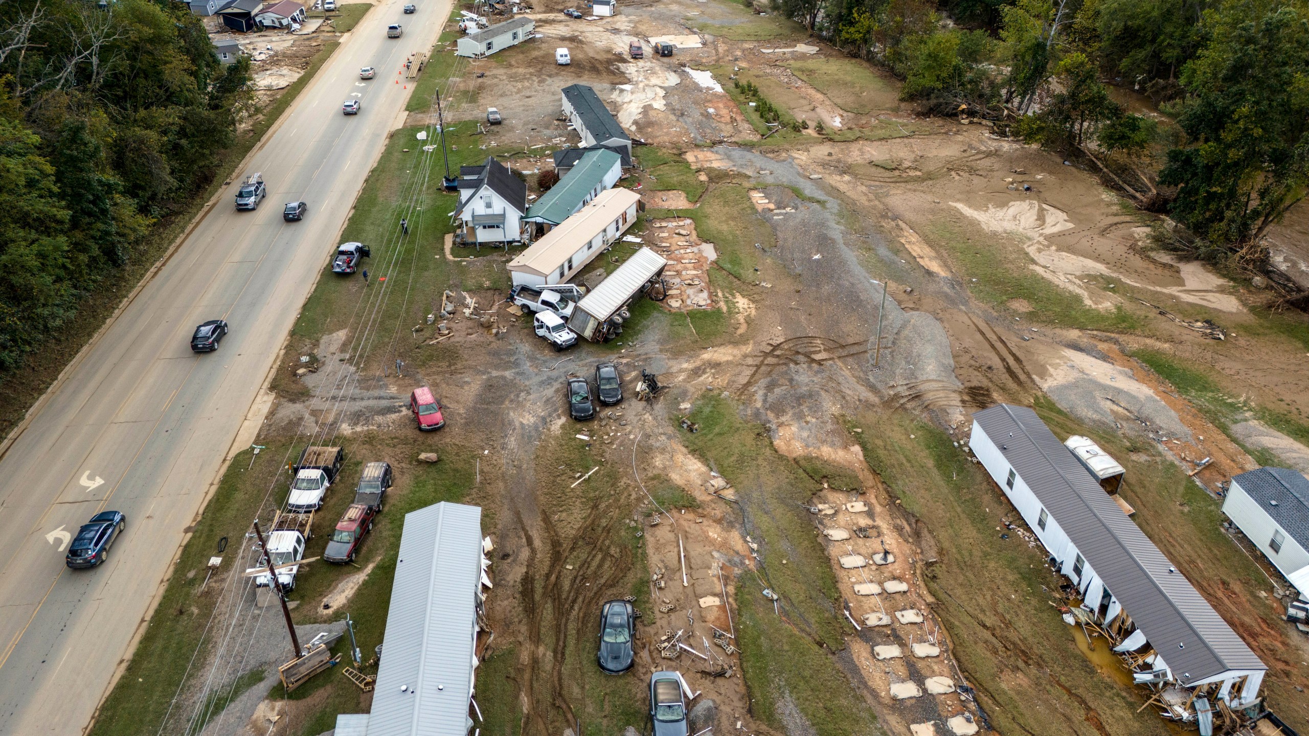 FILE - Homes and vehicles that were damaged in a flood from Hurricane Helene sit on the side of a road near the Swannanoa River, Oct. 1, 2024, in Swannanoa, N.C. (AP Photo/Mike Stewart, File)