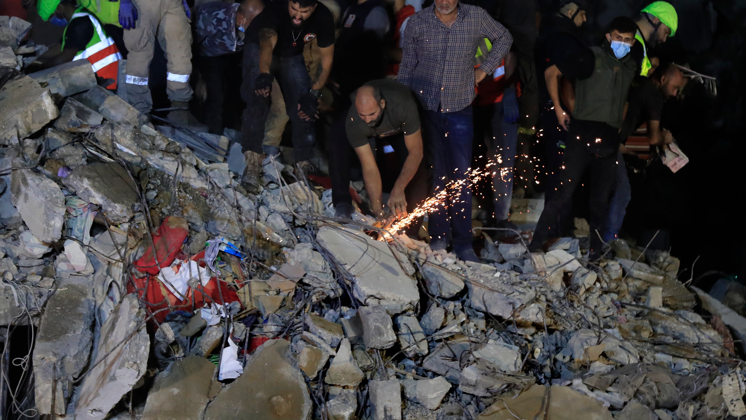 Rescue workers search for victims at a destroyed building hit in an Israeli airstrike, in the southern port city of Sidon, Lebanon, Tuesday, Oct. 29, 2024. (AP Photo/Mohammed Zaatari)