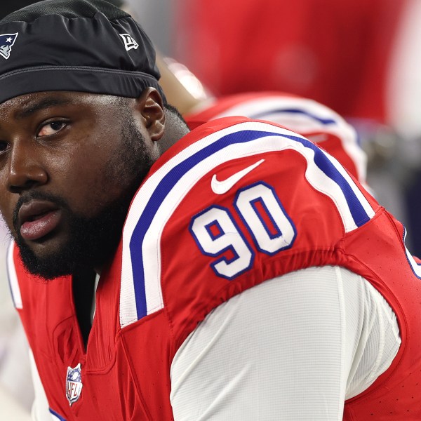 Christian Barmore looks ahead while seated in a red jersey with the number 90 on the sleeve.