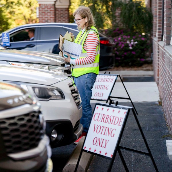 A poll worker assists curbside voters during the first day of early voting at a polling station in Wilmington, North Carolina, US, on Thursday, Oct. 17, 2024.