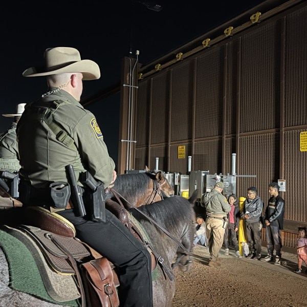 Border Patrol agents on horseback corral a group of migrants who illegally crossed near Penitas, Texas.