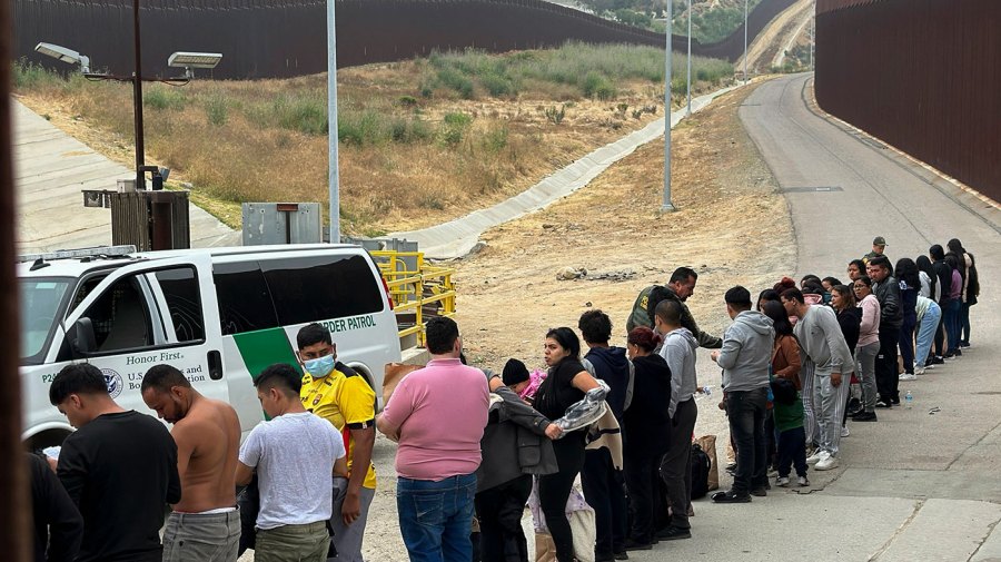 Migrants waiting to be apprehended by Border Patrol agents are depicted.