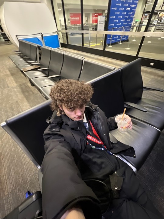 Liam Horgan, a first-year flight attendant with United Airlines, takes a selfie in an airport.