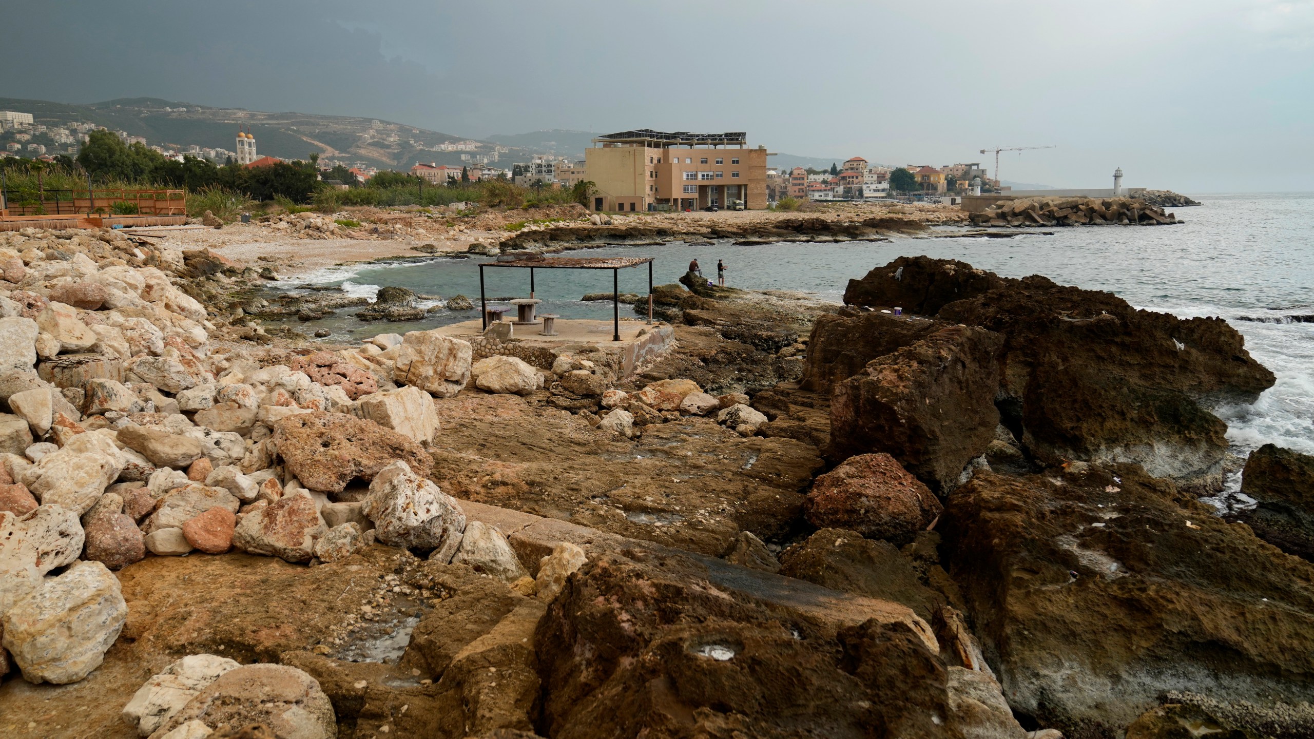 Lebanese fishermen cast their fishing rods at a beach in Batroun, northern Lebanon, Saturday, Nov. 2, 2024, where Lebanese officials say a ship captain was taken away by a group of armed men who landed on a coast north of Beirut and they're investigating whether Israel was involved. (AP Photo/Hussein Malla)