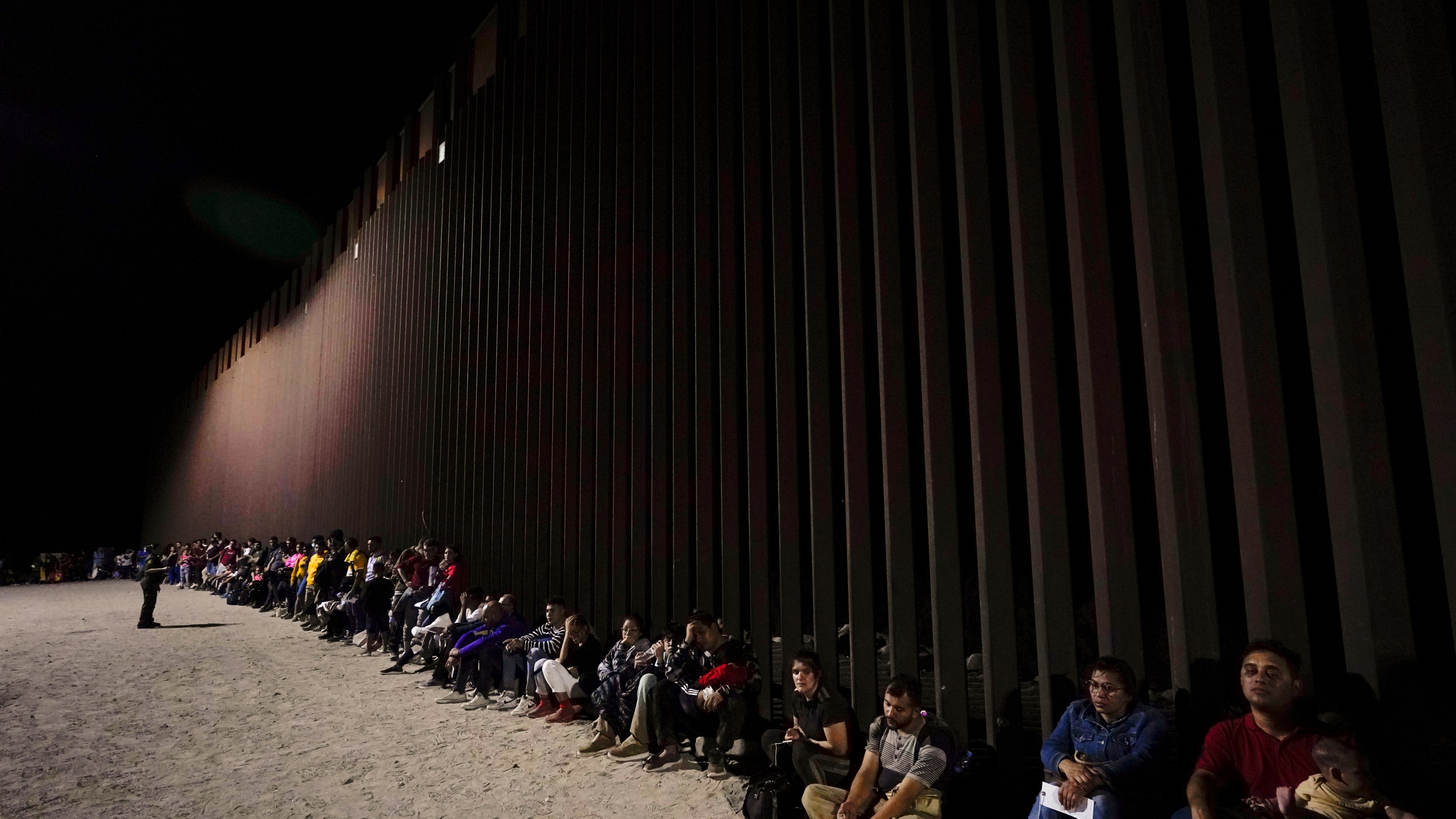 Migrants wait to be processed on Aug. 23, 2022, near Yuma, Ariz.