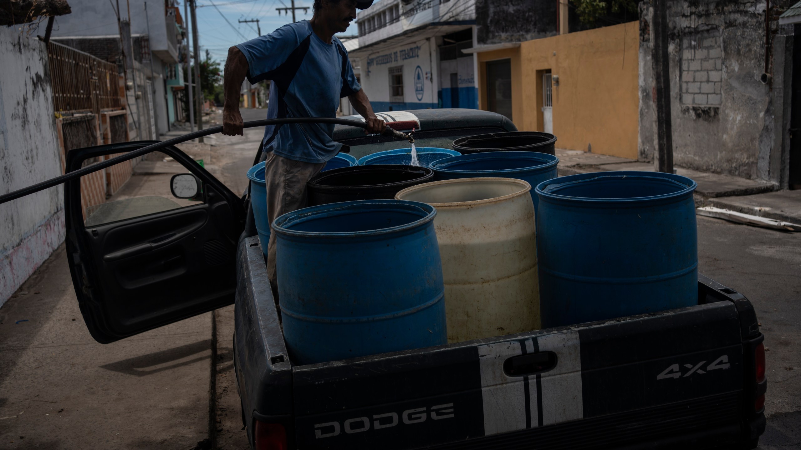 FILE - A man fills containers with water due to the shortage caused by high temperatures and drought in Veracruz, Mexico, on June 16, 2024. (AP Photo/Felix Marquez, File)