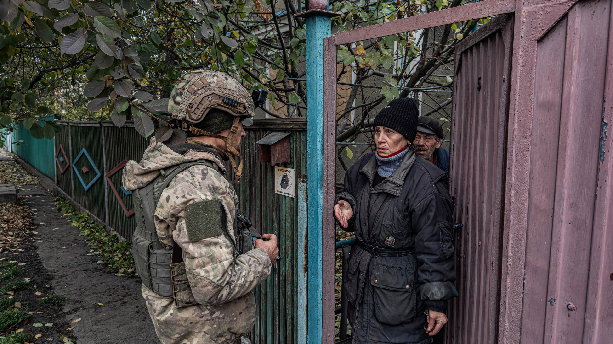 Pipa Vasyl, a policeman of the "White Angels", tries to convince a local woman to evacuate from Kurakhove, Donetsk region, Ukraine, on Nov. 7, 2024. (AP Photo/Anton Shtuka)