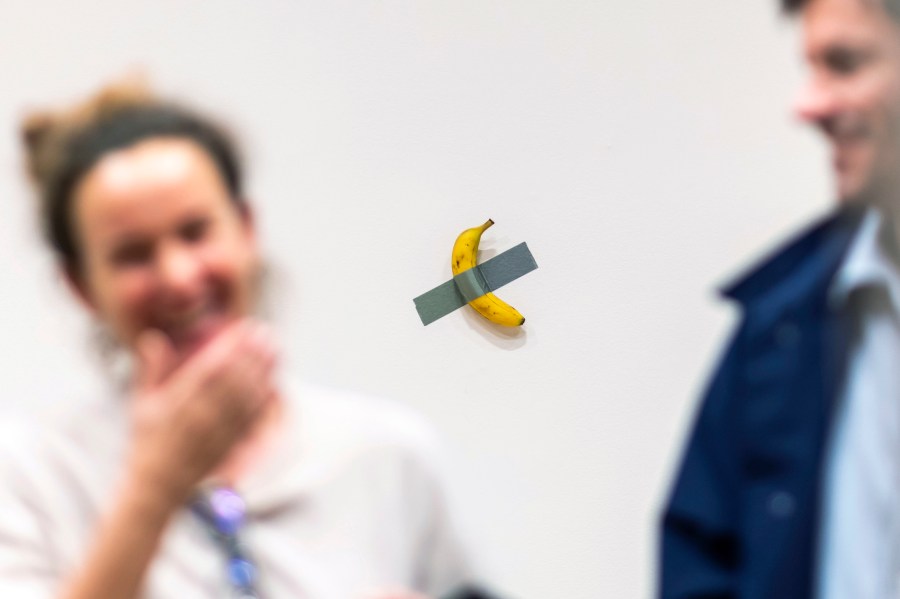 FILE - People react to the artist Maurizio Cattelan's piece of art "Comedian" during an auction preview at Sotheby's in New York, Monday, Nov. 11, 2024. (AP Photo/Eduardo Munoz Alvarez, File)