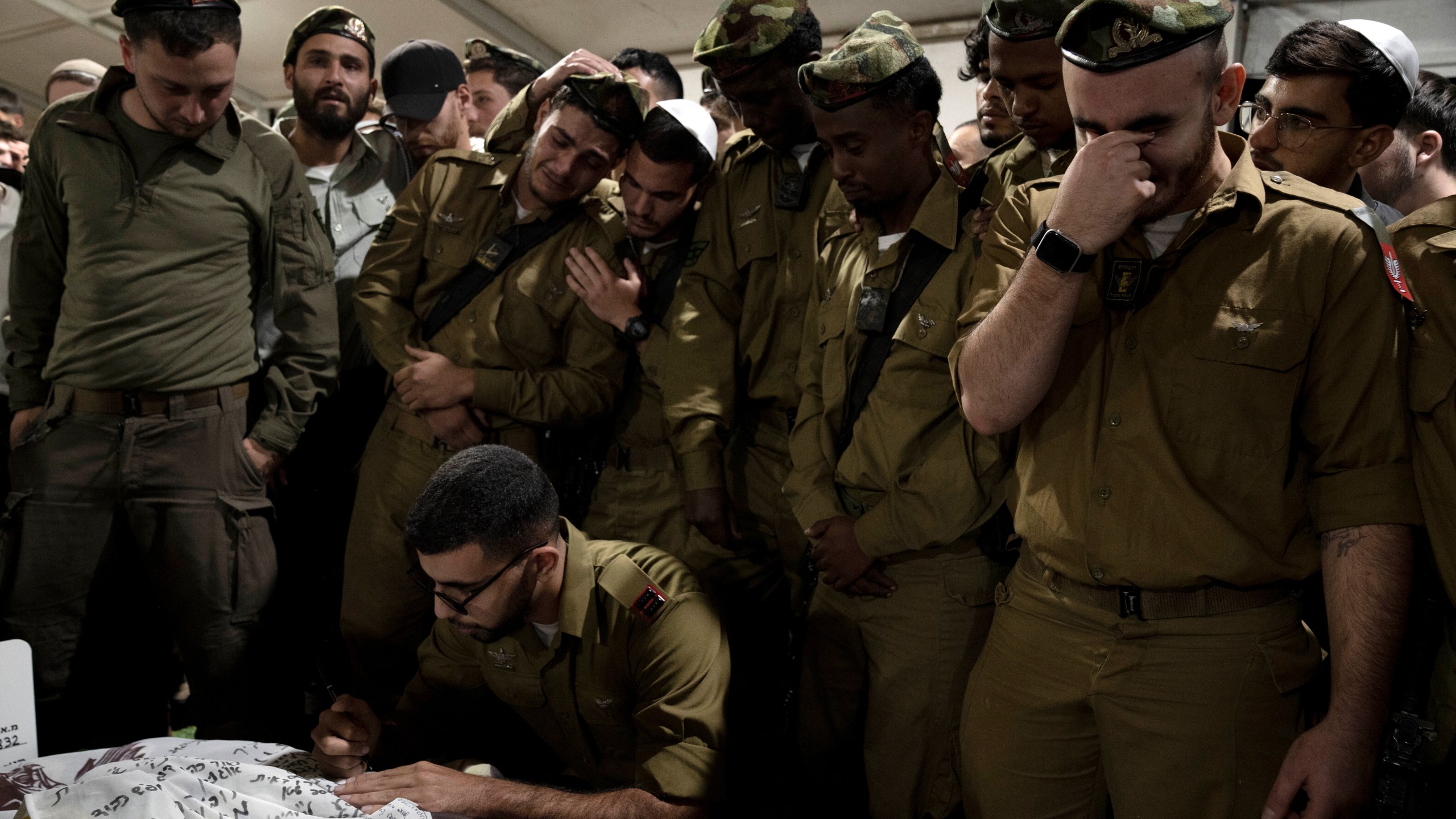 Israeli Defense Forces soldiers mourn at the grave of Sgt. First Class (res.) Roi Sasson, who was killed in action in the Gaza Strip, during his funeral at Mt. Herzl military cemetery in Jerusalem, Wednesday, Nov. 20, 2024. (AP Photo/Maya Alleruzzo)