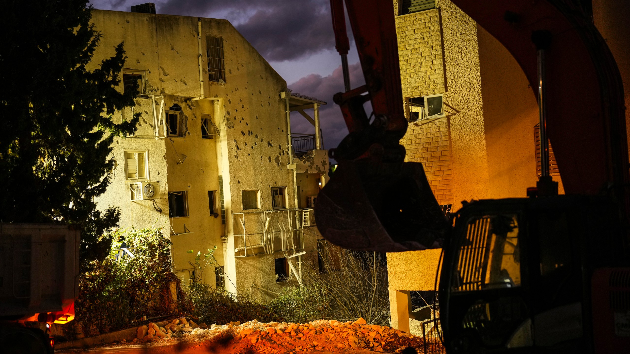 An excavator works at the site where a day before a residential building was hit by a rocket fired from Lebanon, in Haifa, Israel, Monday, Nov. 25, 2024. (AP Photo/Francisco Seco)