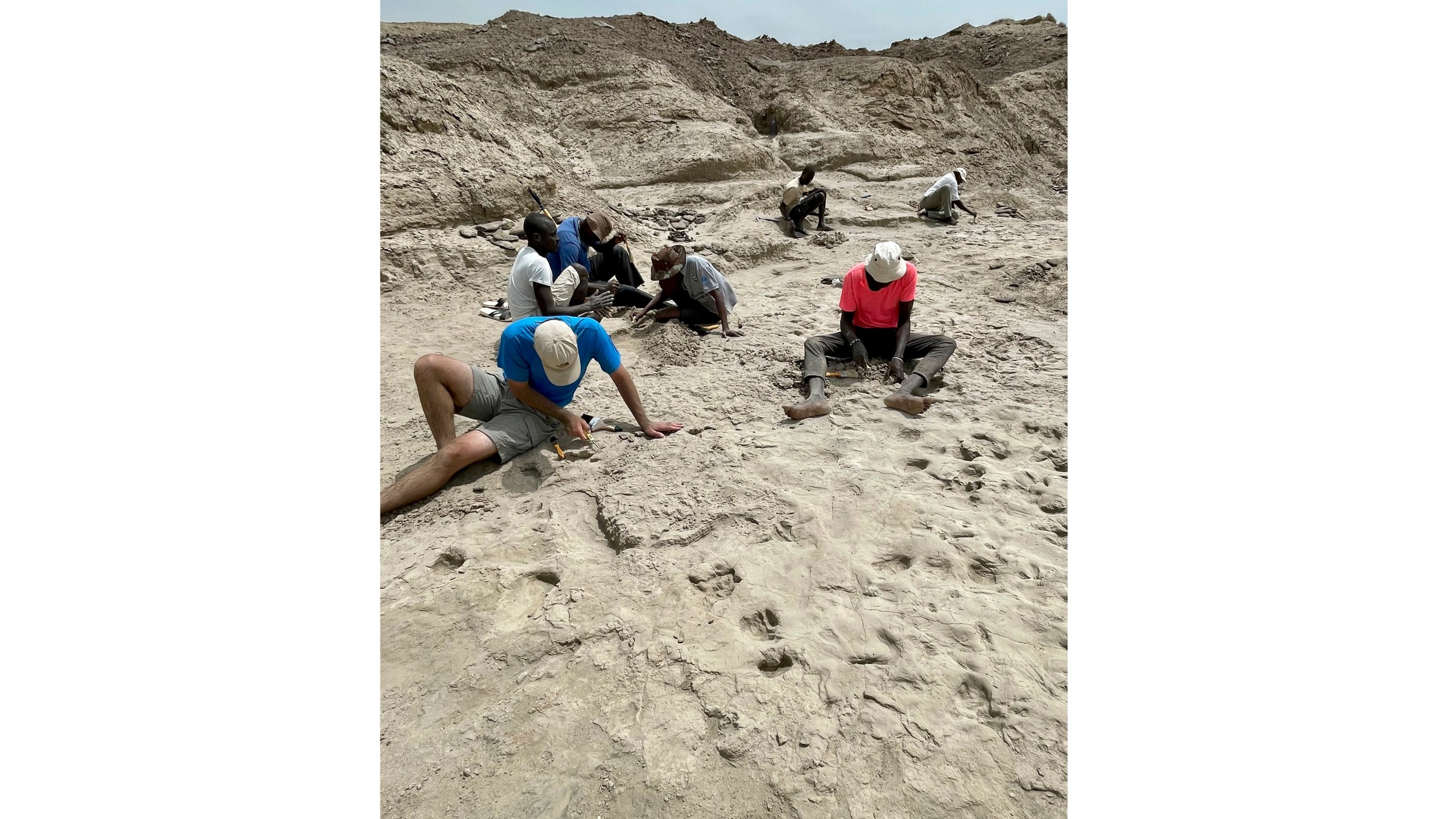 Scientists study fossil footprints for clues about co-existing species of early human ancestors at the excavation site on the eastern side of Lake Turkana in northern Kenya, in 2022. (Neil Thomas Roach via AP)