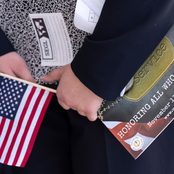 A flag is held at the National Veterans Day Observance in Arlington, Va., Monday, Nov. 11, 2024.