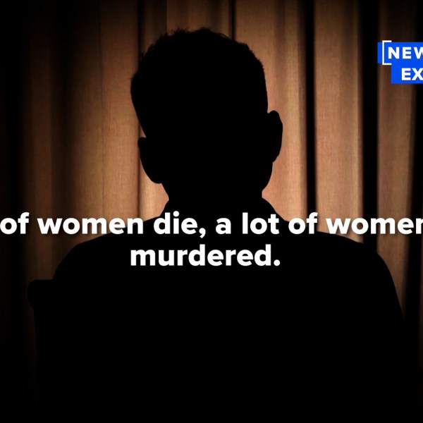 An unidentifiable man sits in a dark room during an interview.