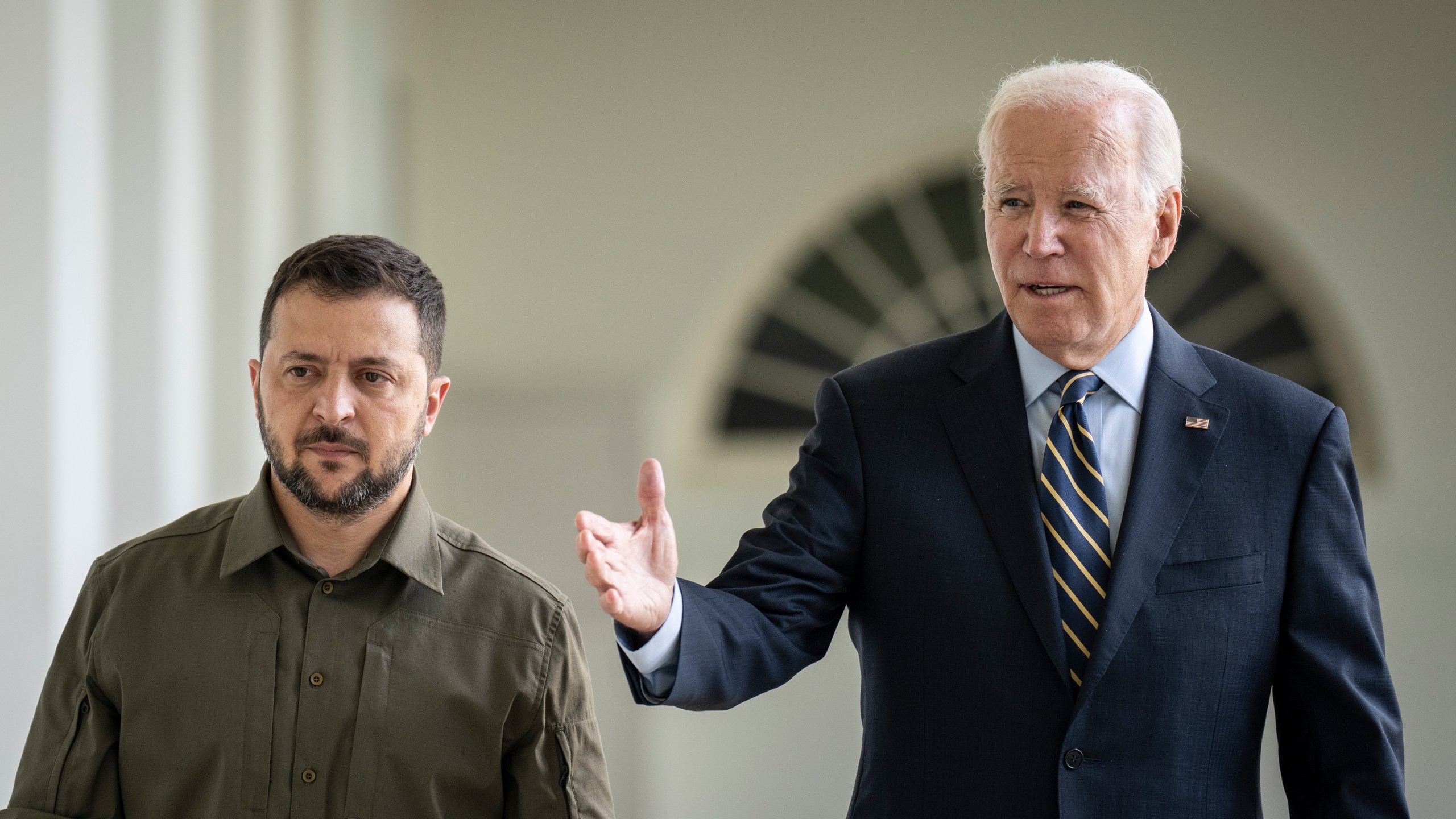 President Joe Biden walks with Ukrainian President Volodymyr Zelenskyy.