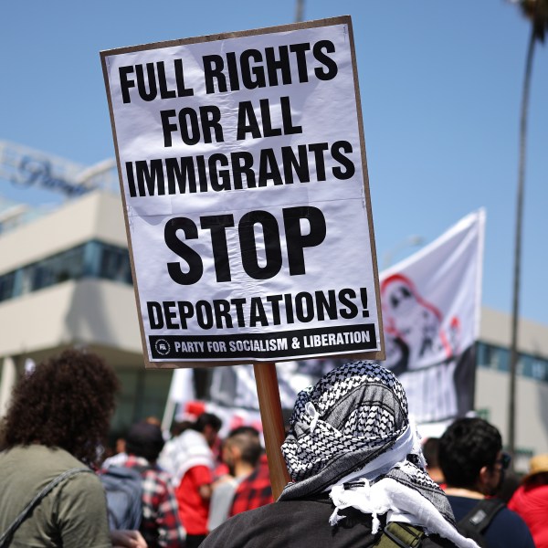A sign reads 'Stop Deportations' during a May Day march through Hollywood