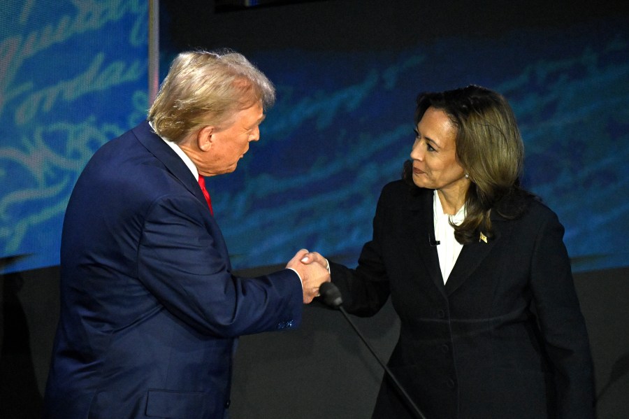 Donald Trump and Kamala Harris shaking hands.