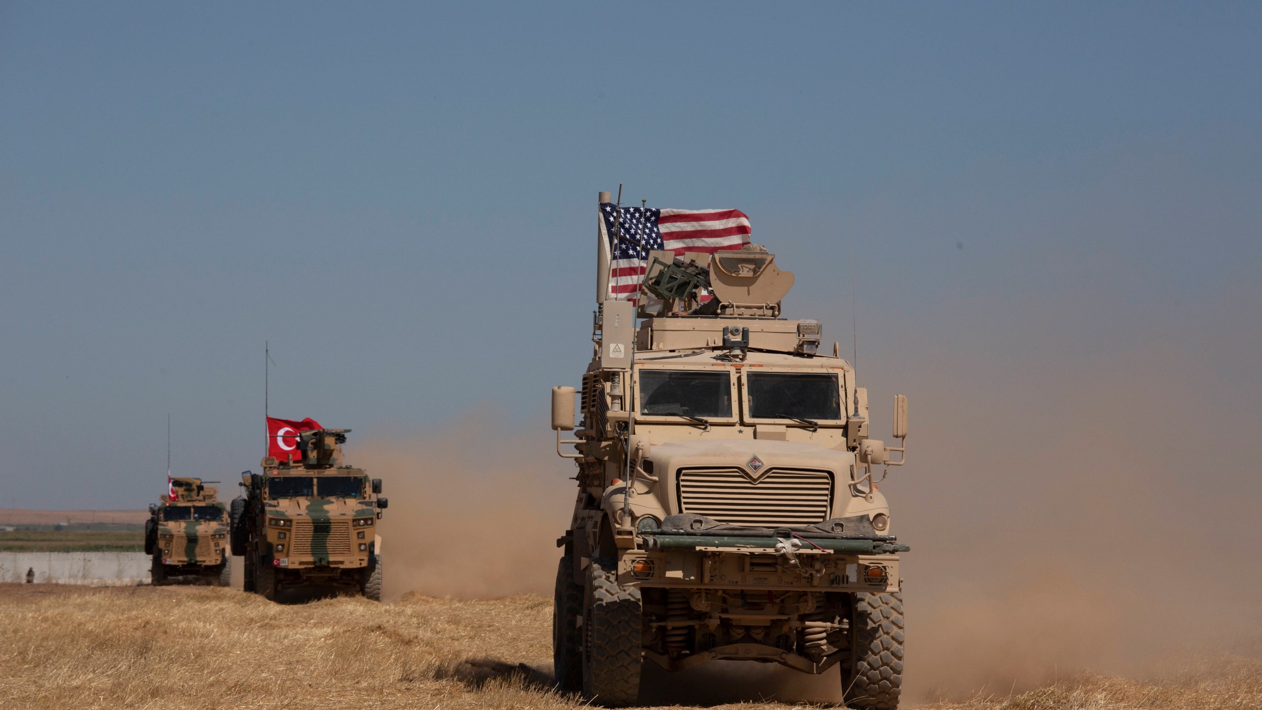 FILE - Turkish and American armored vehicles conduct the first joint patrol in the so-called "safe zone" on the Syrian side of the border with Turkey near Tal Abyad, Syria, Sept. 8, 2019. (AP Photo/Maya Alleruzzo, File)