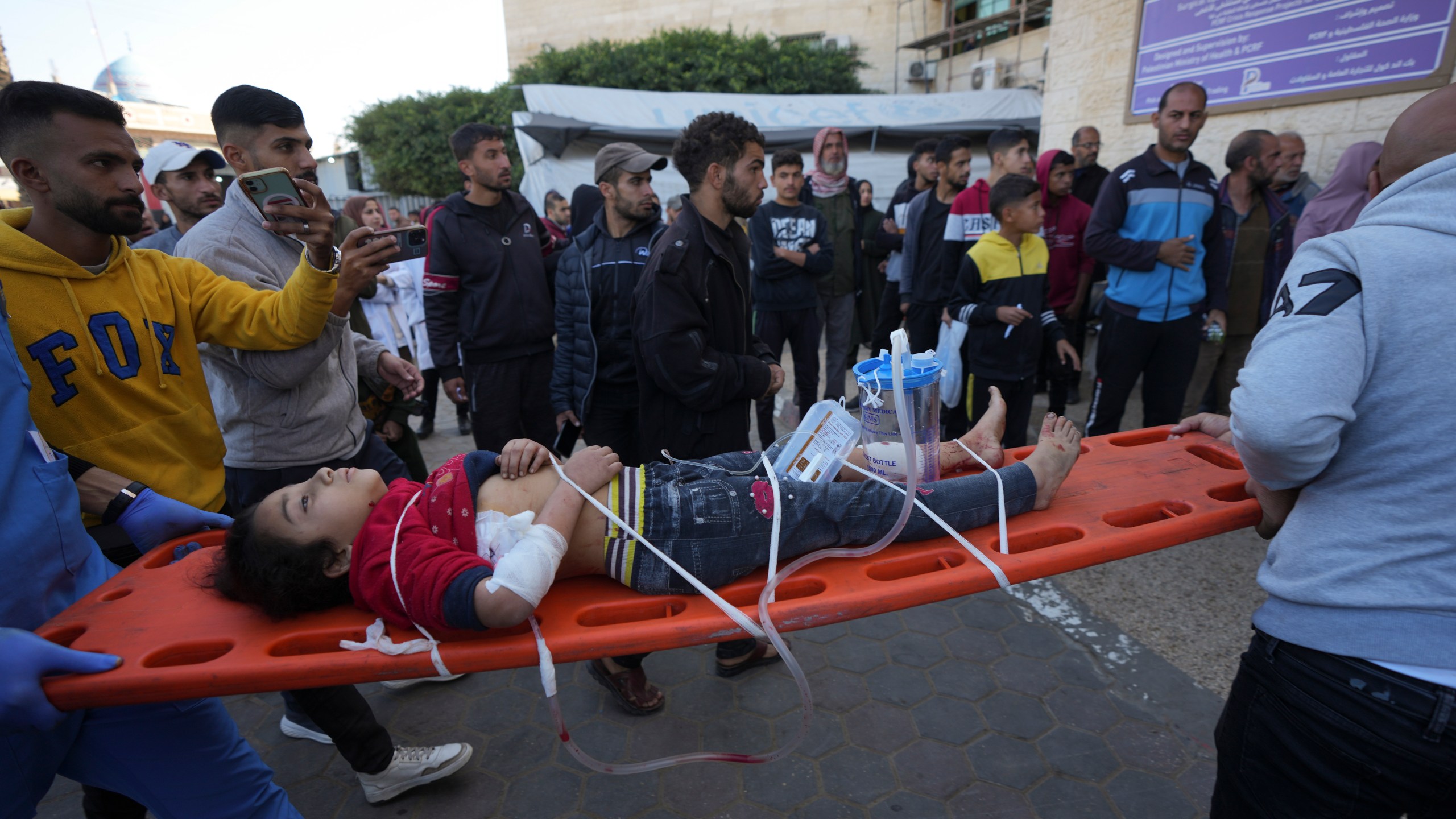 A wounded Palestinian child is carried on a stretcher at the Al-Aqsa Martyrs hospital in Deir al-Balah, following an Israeli bombardment in Nuseirat, central Gaza, Wednesday, Dec. 4, 2024. (AP Photo/Abdel Kareem Hana)