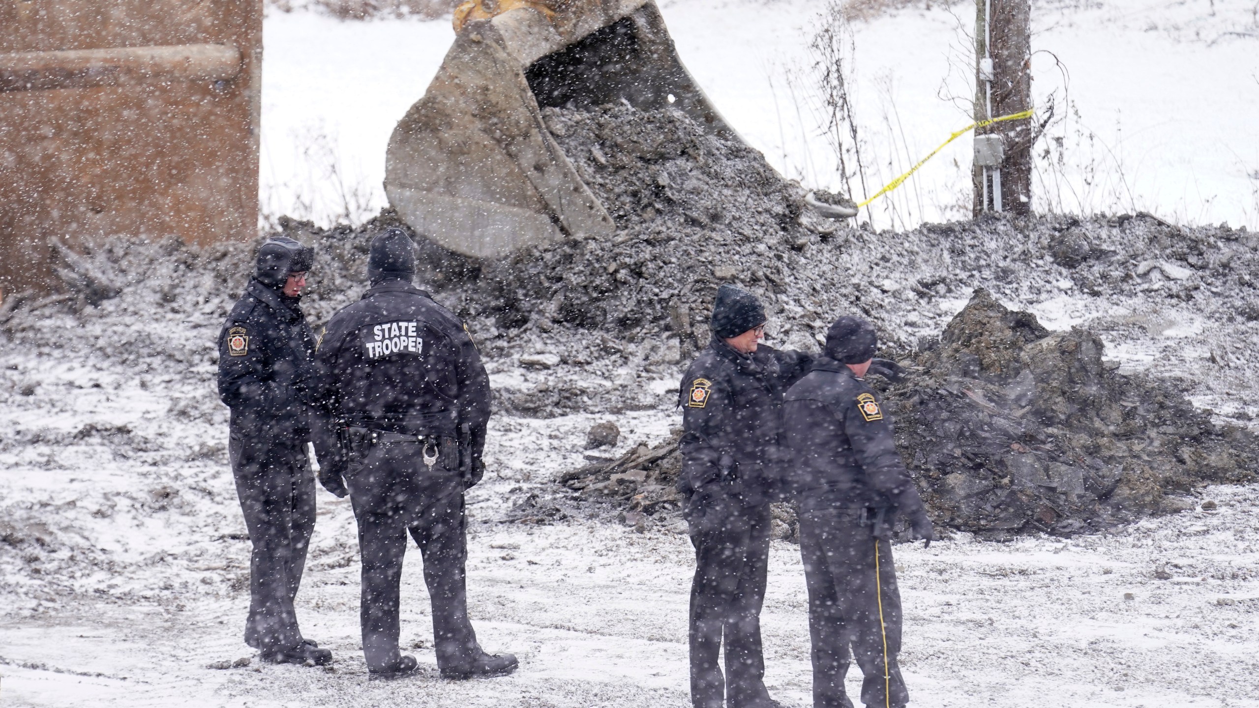 Law enforcement members watch as rescue workers continue to search, Thursday, Dec. 5, 2024, for Elizabeth Pollard, who is believed to have disappeared in a sinkhole while looking for her cat, in Marguerite, Pa. (AP Photo/Matt Freed)