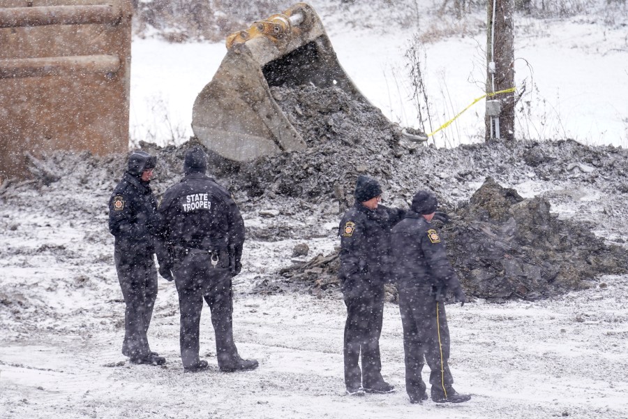 Law enforcement members watch as rescue workers continue to search, Thursday, Dec. 5, 2024, for Elizabeth Pollard, who is believed to have disappeared in a sinkhole while looking for her cat, in Marguerite, Pa. (AP Photo/Matt Freed)