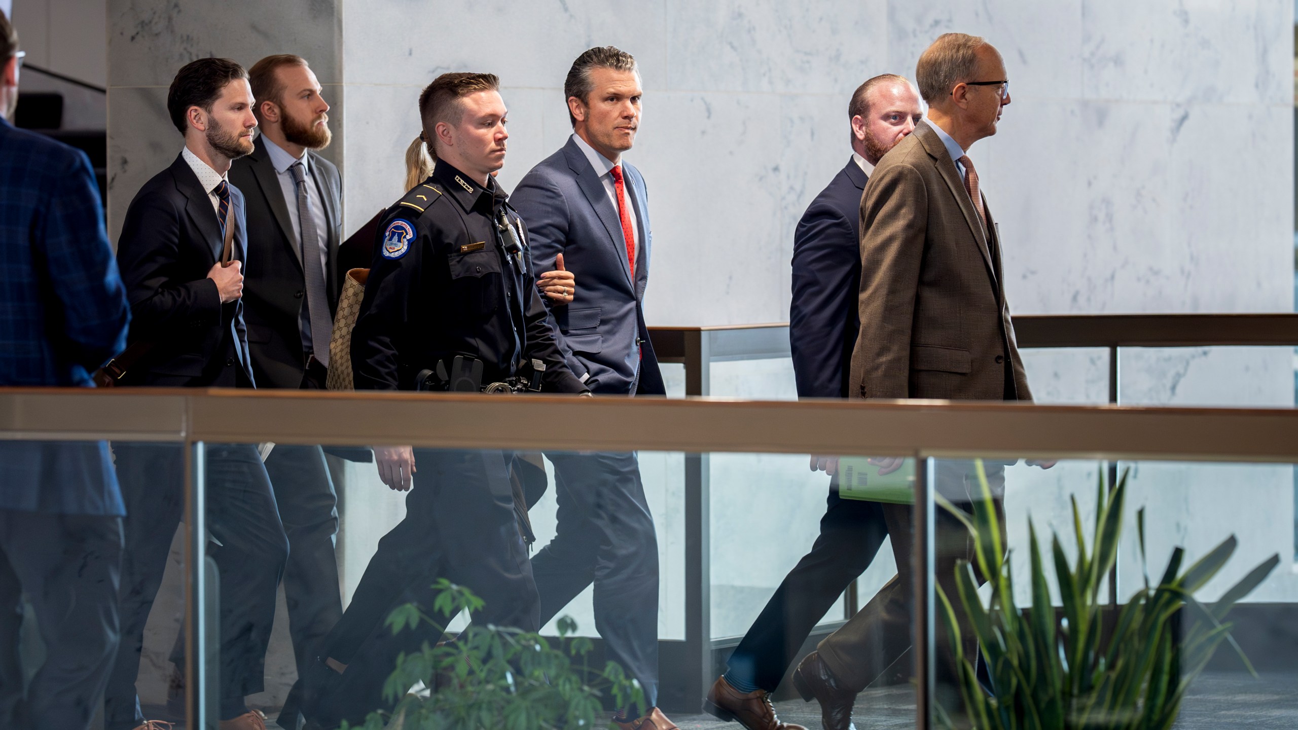 Pete Hegseth, center, President-elect Donald Trump's nominee to be defense secretary, is escorted to meet with Sen. Mike Rounds, R-S.D., a member of the Senate Armed Services Committee, at the Capitol in Washington, Thursday, Dec. 5, 2024. (AP Photo/J. Scott Applewhite)