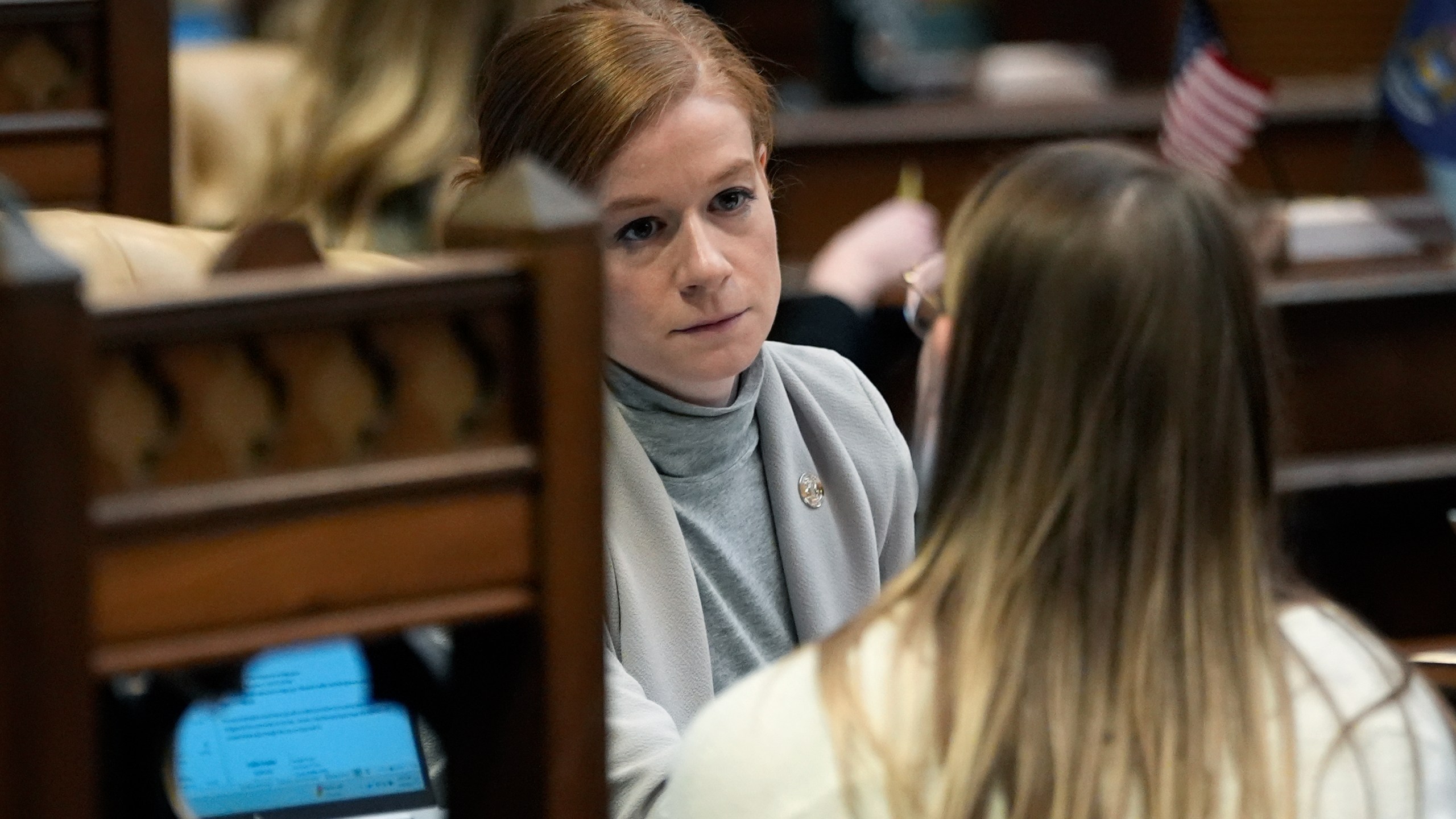 Michigan State Sen. Mallory McMorrow talks with a staffer on the Senate floor, Wednesday, Dec. 4, 2024, in Lansing, Mich. (AP Photo/Carlos Osorio)