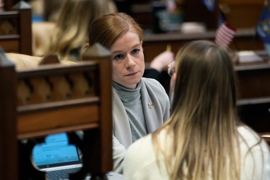 Michigan State Sen. Mallory McMorrow talks with a staffer on the Senate floor, Wednesday, Dec. 4, 2024, in Lansing, Mich. (AP Photo/Carlos Osorio)