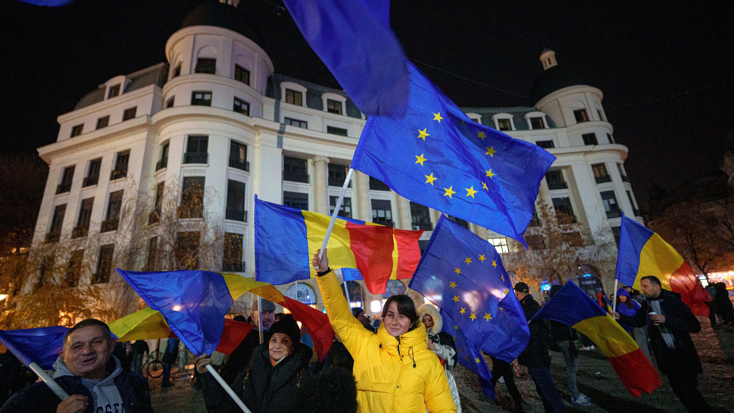 People wave Romanian and European Union flags during a pro-European rally ahead of the country's Dec. 8 runoff presidential elections in Bucharest, Romania, Thursday, Dec. 5, 2024. (AP Photo/Andreea Alexandru)