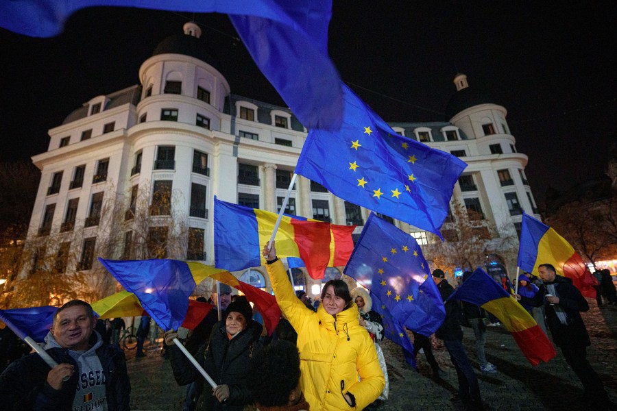 People wave Romanian and European Union flags during a pro-European rally ahead of the country's Dec. 8 runoff presidential elections in Bucharest, Romania, Thursday, Dec. 5, 2024. (AP Photo/Andreea Alexandru)