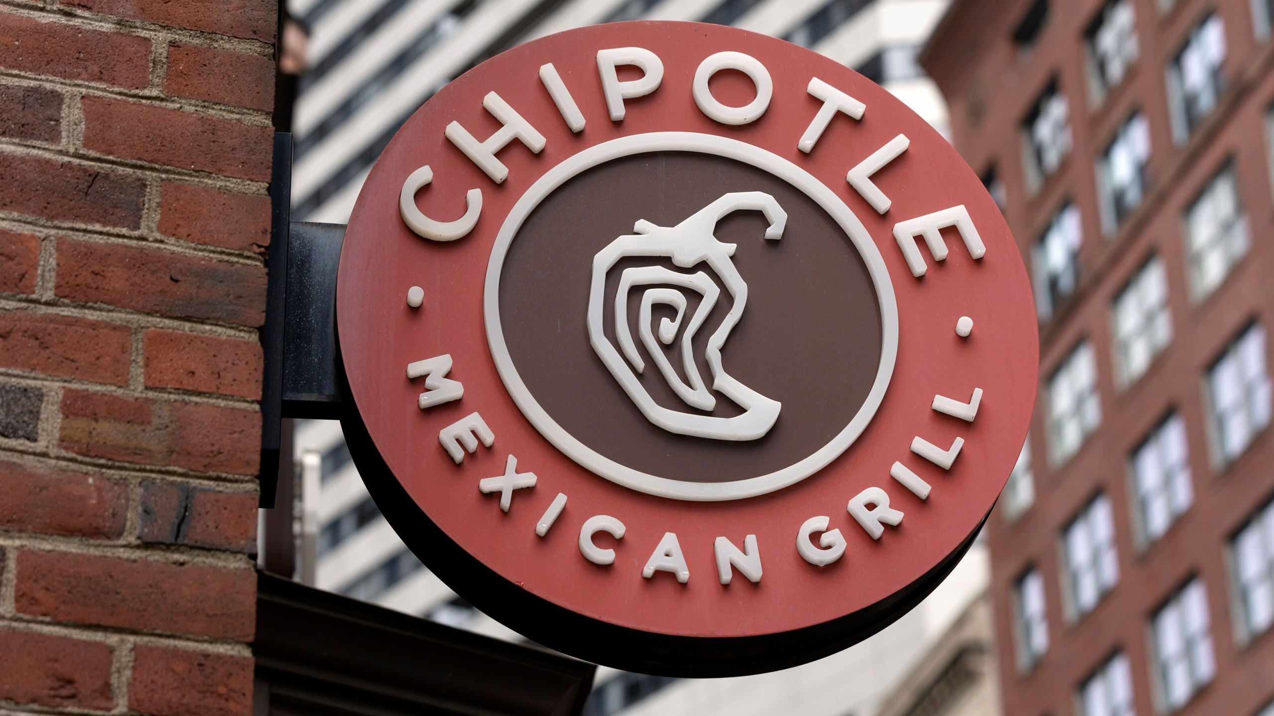 FILE - The Chipotle Mexican Grill logo is seen on a storefront, Oct. 14, 2022, in Boston. (AP Photo/Michael Dwyer, File)
