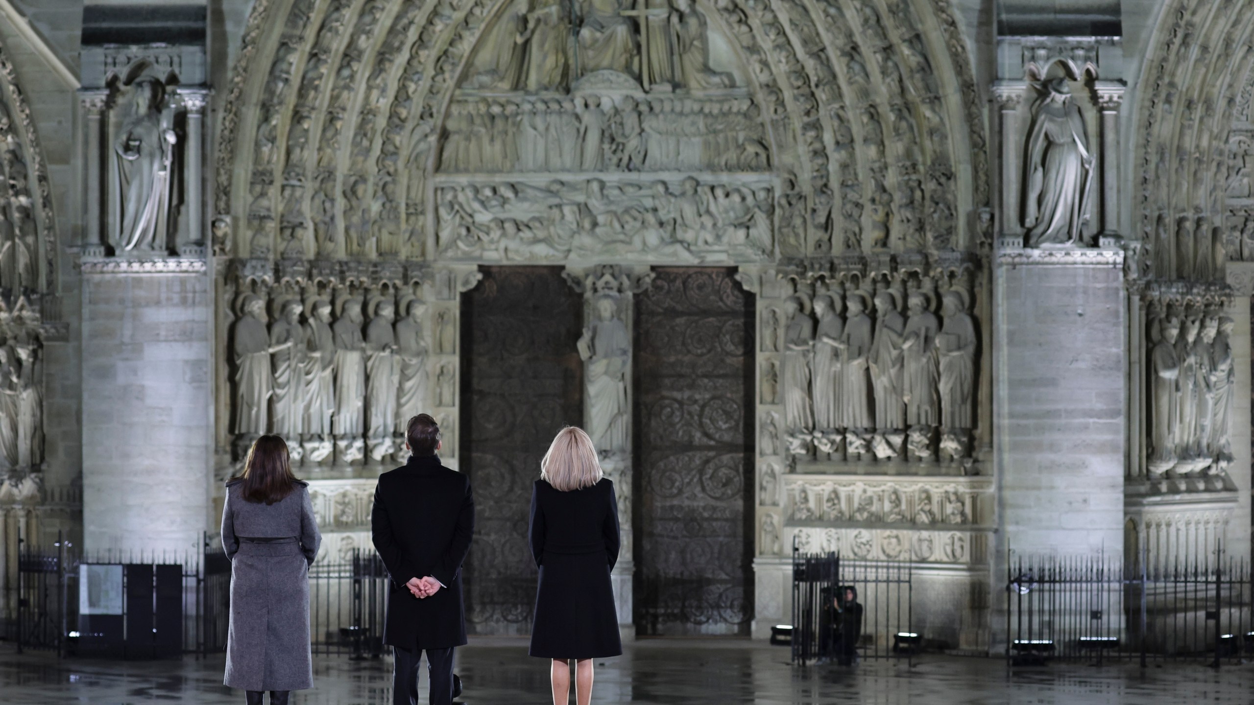 French President Emmanuel Macron his wife Brigitte and Paris' mayor Anne Hidalgo, left, stand outside France's iconic Notre Dame Cathedral Saturday, Dec. 7, 2024 in Paris during it's formal reopening. (Christophe Petit-Tesson, Pool via AP)