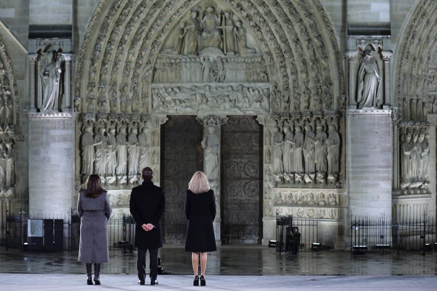 French President Emmanuel Macron his wife Brigitte and Paris' mayor Anne Hidalgo, left, stand outside France's iconic Notre Dame Cathedral Saturday, Dec. 7, 2024 in Paris during it's formal reopening. (Christophe Petit-Tesson, Pool via AP)