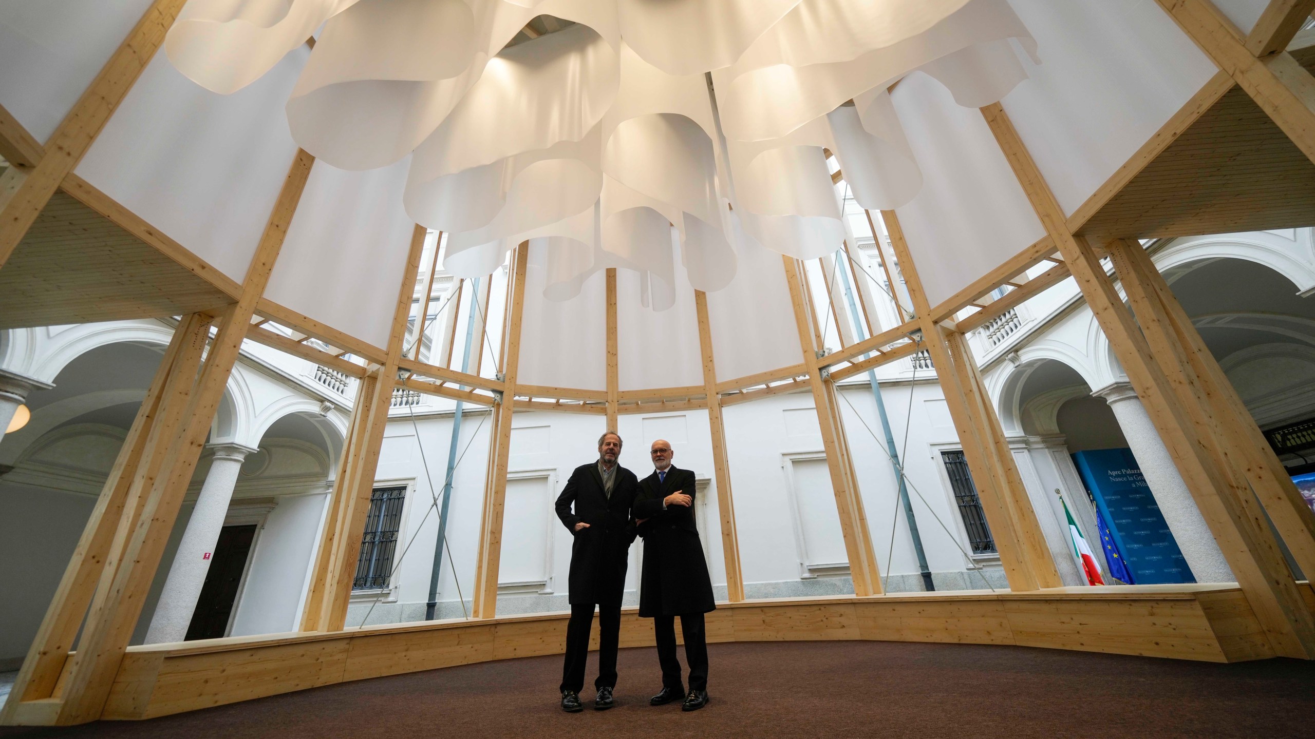 Grande Brera Museum director, Angelo Crespi, right, poses flanked by designer Mario Cucinella inside a wooden temple, at Palazzo Citterio Museum in Milan, Italy, Saturday Dec. 7, 2024. (AP Photo/Luca Bruno)