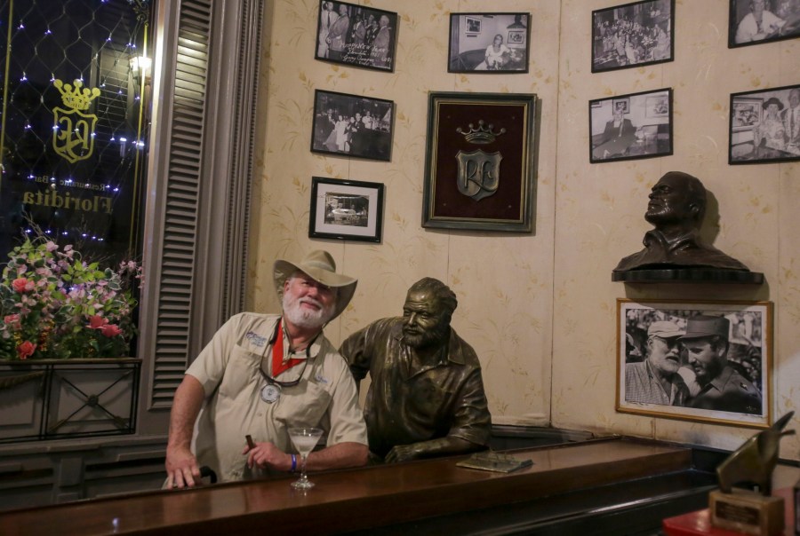 A man who pretends to look like the late American writer Ernest Hemingway poses for a photo recalling passages from the life and work of 1954 Nobel Prize-winning writer Ernest Hemingway at La Floridita bar in Havana, Cuba, Saturday, Dec, 6, 2024. (AP Photo/ Ariel Ley)