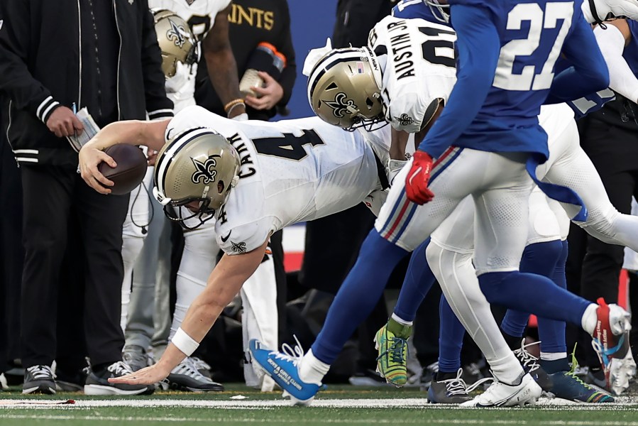New Orleans Saints quarterback Derek Carr (4) comes down on his arm as he is tackled by the New York Giants during the fourth quarter of an NFL football game, Sunday, Dec. 8, 2024, in East Rutherford, N.J. (AP Photo/Adam Hunger)