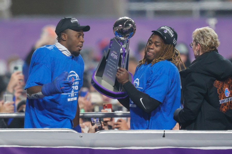 Boise State safety Seyi Oladipo, left, the defensive player of the game, and running back Ashton Jeanty, right, the offensive player of the game, celebrate with the Championship Trophy after their matchup against UNLV in the Mountain West Championship NCAA college football game Friday, Dec. 6, 2024, in Boise, Idaho. (AP Photo/Steve Conner)