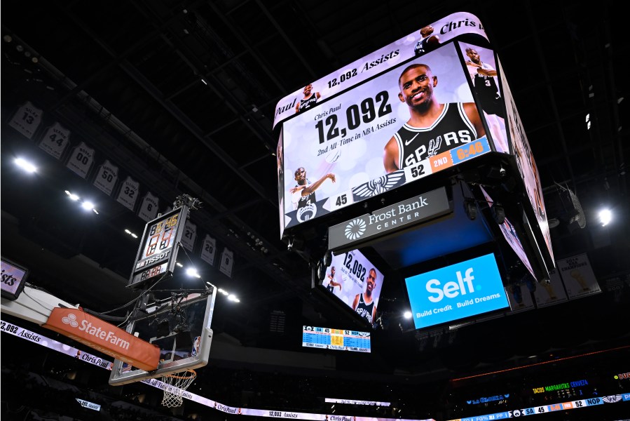 The San Antonio Spurs display a graphic congratulating Spurs guard Chris Paul for surpassing Jason Kidd for second all-time NBA assists, during the first half of an NBA basketball game against the New Orleans Pelicans, Sunday, Dec. 8, 2024, in San Antonio. (AP Photo/Darren Abate)