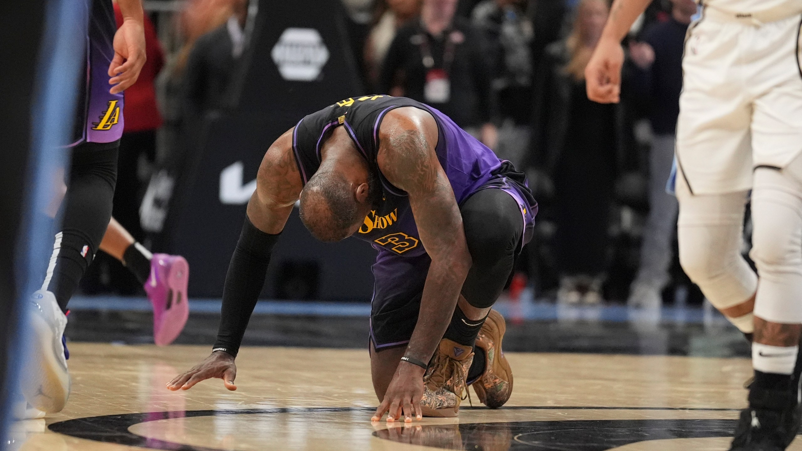 Los Angeles Lakers forward LeBron James (23) kneels on the court in the second half of an NBA basketball game against the Atlanta Hawks, Friday, Dec. 6, 2024, in Atlanta. (AP Photo/Brynn Anderson)